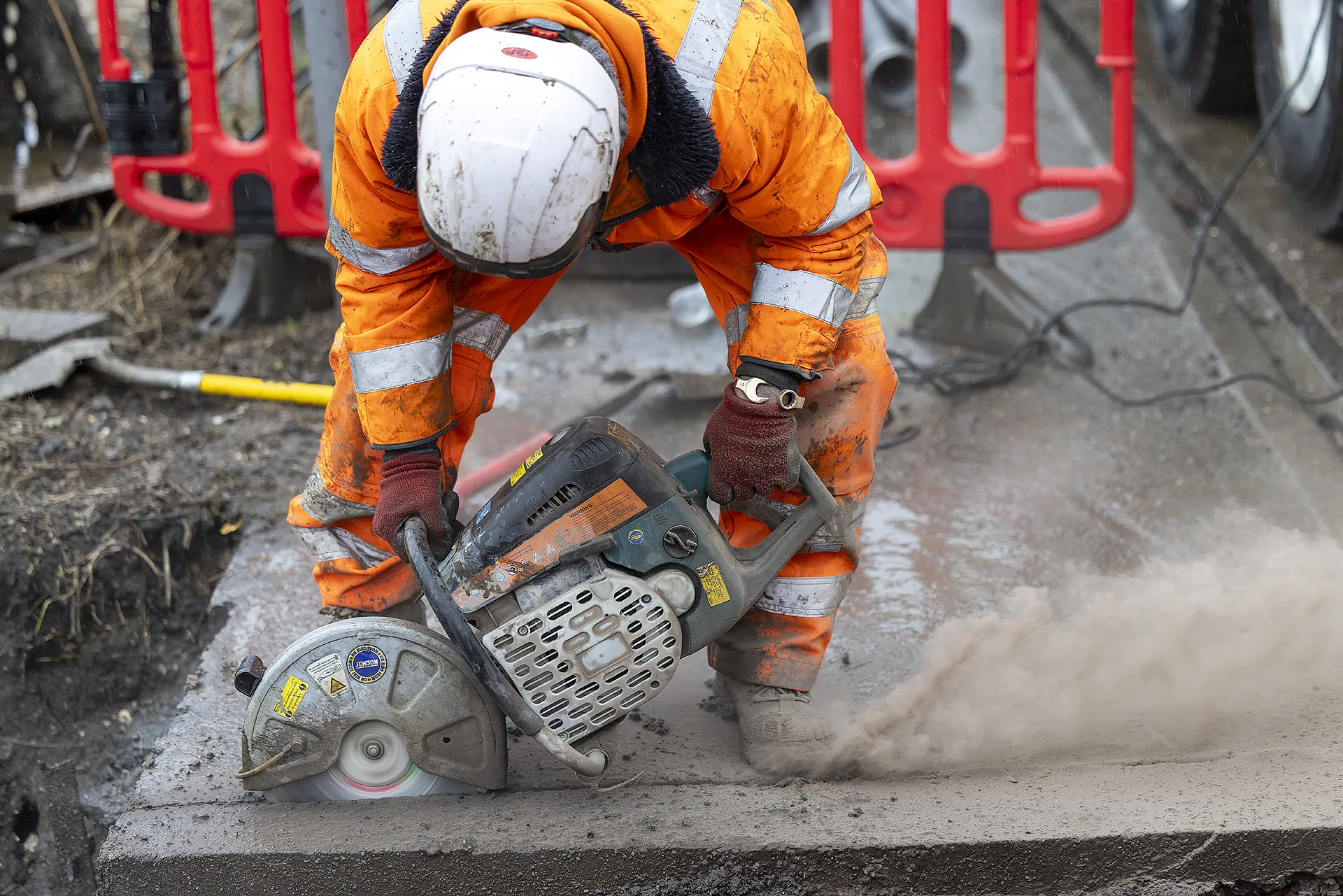 Engineer cutting concrete during construction works for a temporary water infrastructure project.